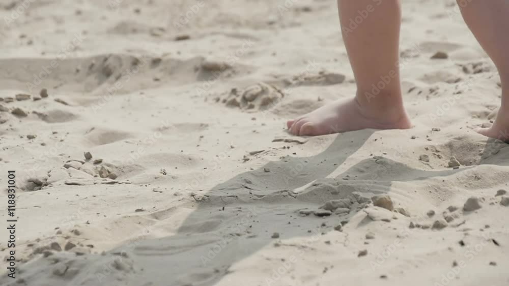 Children's legs running on the sand, slow motion