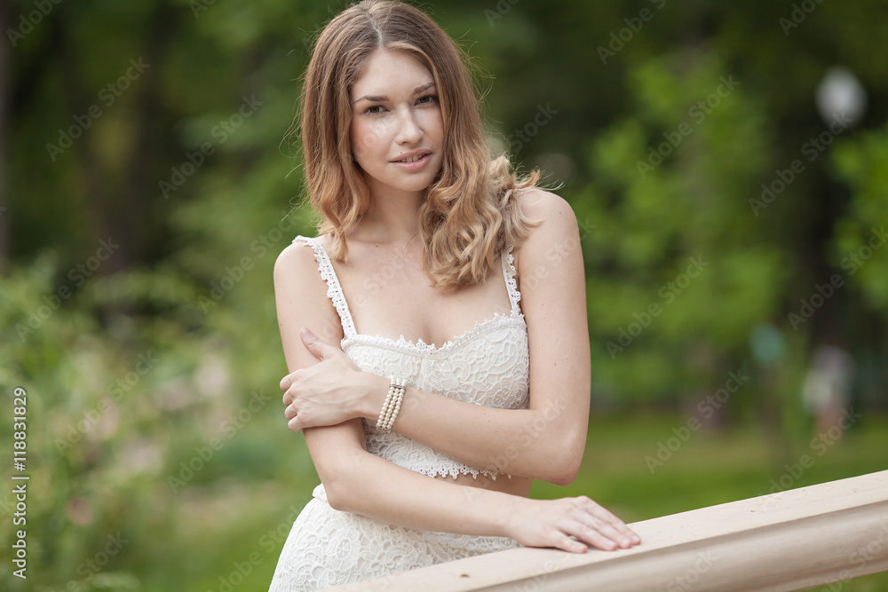 Fototapeta premium Portrait Of Young Beautiful Woman. beautiful young brunette fashion model posing outdoor. Summer outdoor portrait. Focus on woman, blurred background
