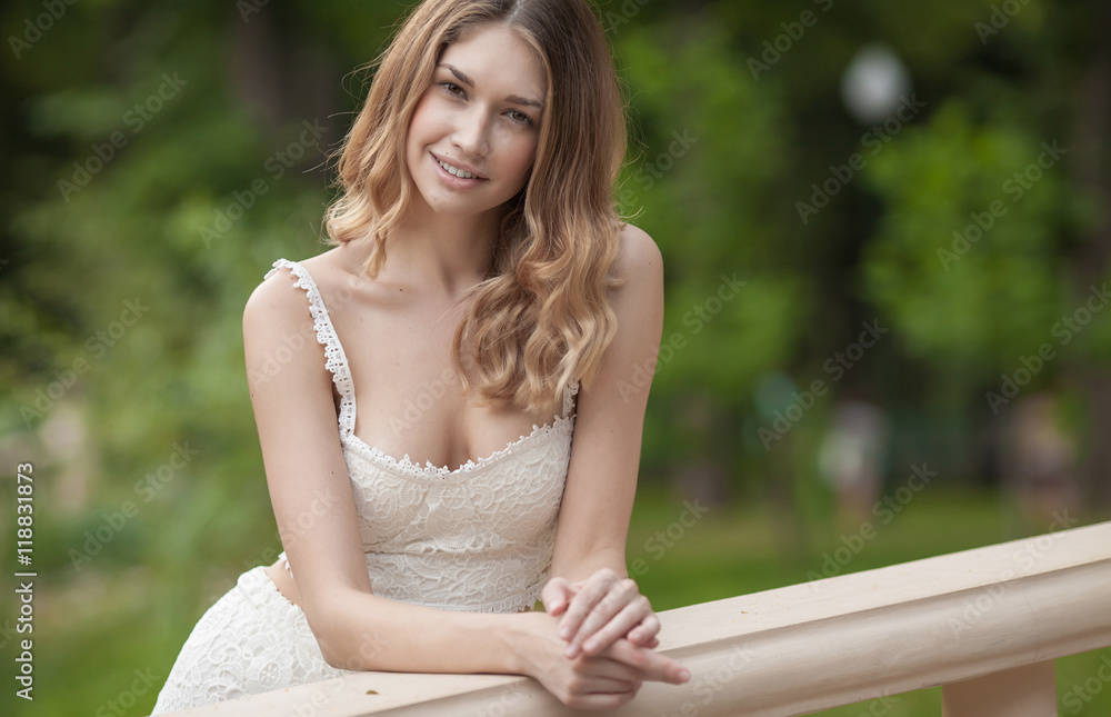 Naklejka premium Portrait Of Young Beautiful Woman. beautiful young brunette fashion model posing outdoor. Summer outdoor portrait. Focus on woman, blurred background