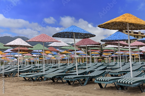 Straw umbrellas with chairs on beach