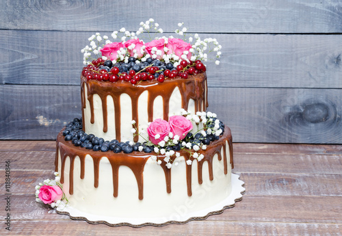 two layered color drip wedding cake with bilberries, red currant