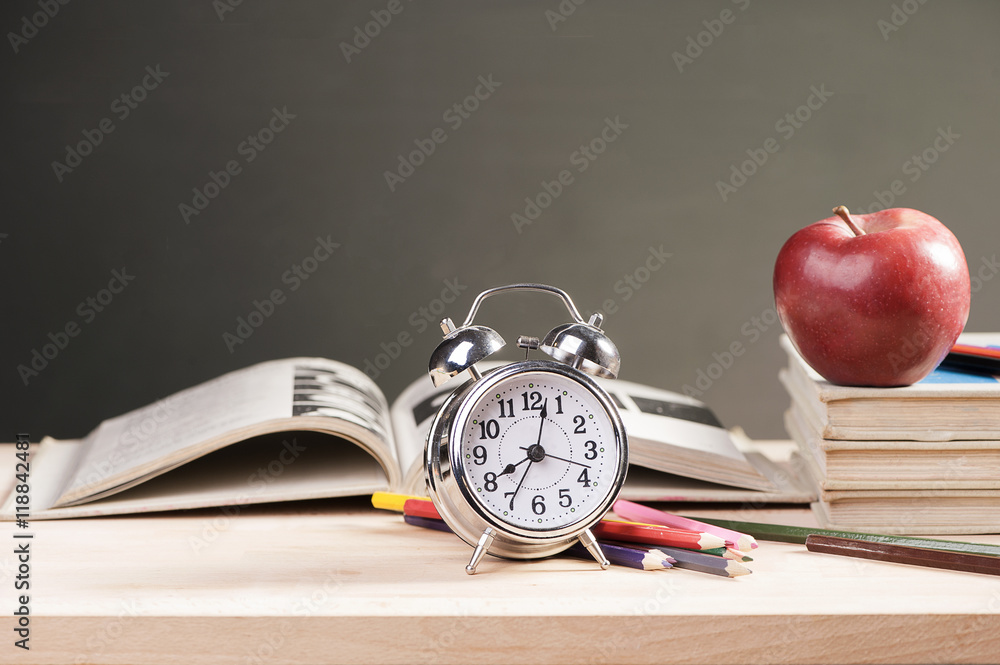 School books and apple against blackboard School books and apple against blackboard