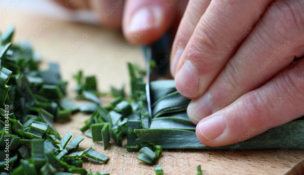 Cutting leek on wood chop board . Cutting leek on wood chop board .