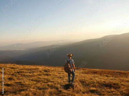 Man, travallerwith a backpack & hat in the mountains