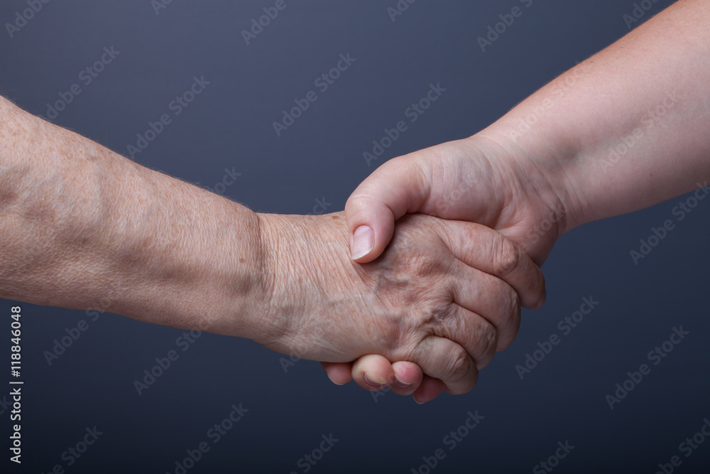 Hands of elderly and young women on black background Hands of elderly and young women on black background