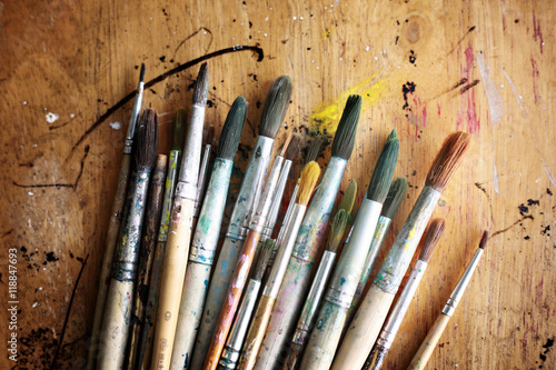 Group of old used paint brushes on a rustic wooden table. 