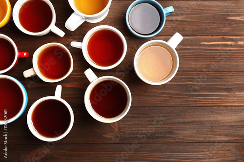 Cups of tea on wooden background, top view