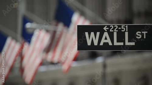 Wall Street sign with flags purposely blurred in background, lower Manhattan, downtown New York City, HD video
