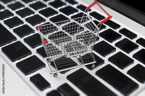 online shopping concept with 3d rendering shopping cart on keyboard