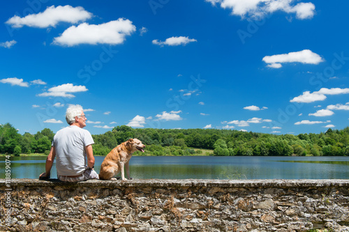 Senior man with old dog in nature landscape photo