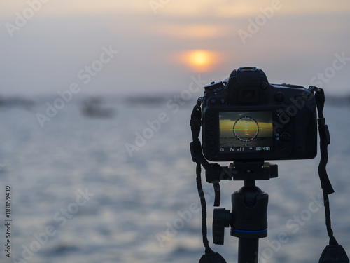 Closeup of a camera on a tripod outdoors. Background Landscape out of focus 