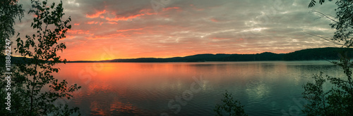 bright sunrise on the bank of forest lake