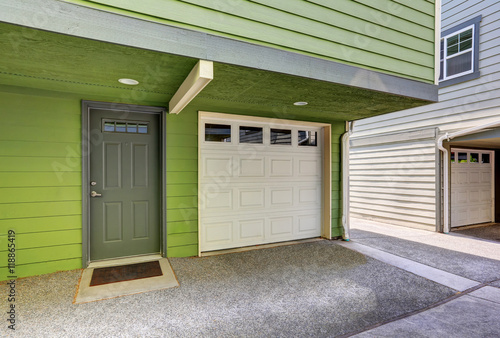 Small entrance porch and garage door of duplex house.