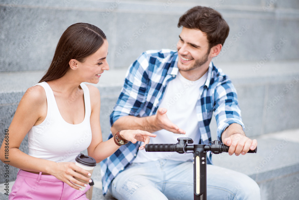 Fototapeta premium Cheerful friends discussing scooter