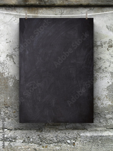 Close-up of one blank blackboard frame hanged by pegs against scratched wall background