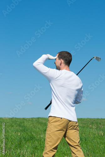 golfer looking away defensively from the sun hand