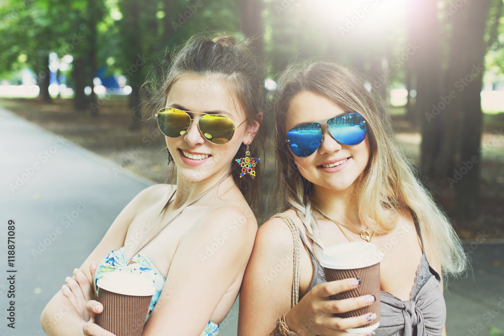 Two beautiful young boho chic stylish girls walking in park. Two beautiful young boho chic stylish girls walking in park.