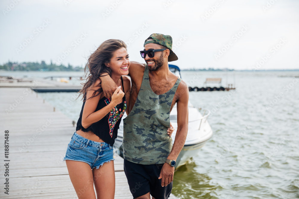 Portrait of romantic young couple standing at the wooden pier