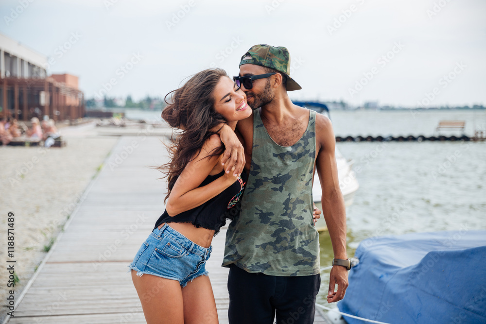 Happy young couple kissing at the wooden pier