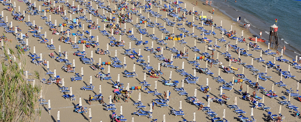 molti ombrelloni chiusi sulla spiaggia