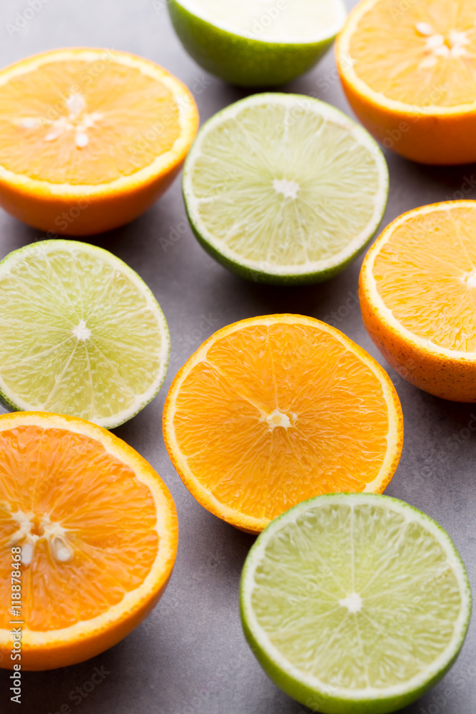Fototapeta premium Mixed citrus fruit lemons, orange, kiwi, limes on a gray backgro