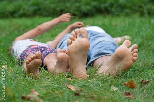 Dad and daughter lying on green grass