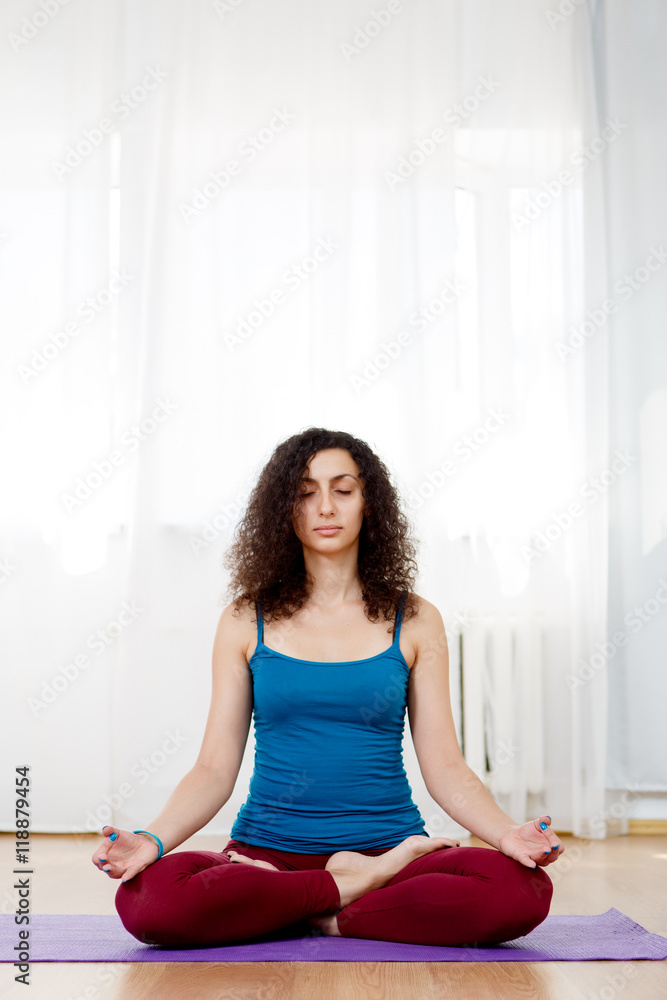 Young slim brunette woman in lotus position with eyes closed Young slim brunette woman in lotus position with eyes closed