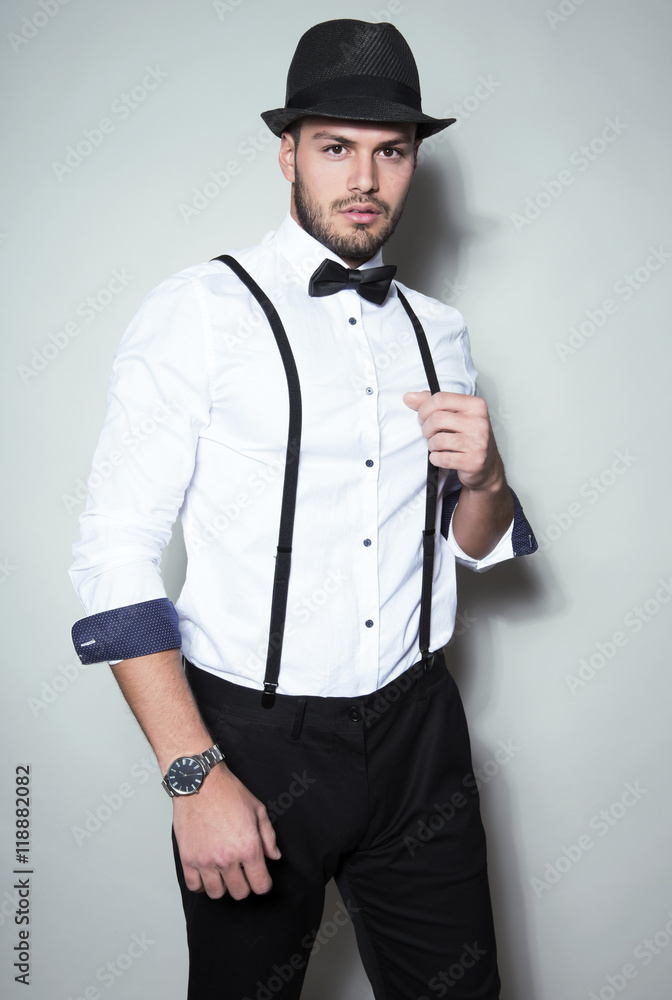 handsome young man wearing hat, suspenders, bow tie and a watch
handsome young man wearing hat, suspenders, bow tie and a watch
