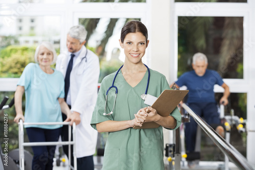 Smiling Female Physiotherapist Holding Clipboard In Fitness Cent