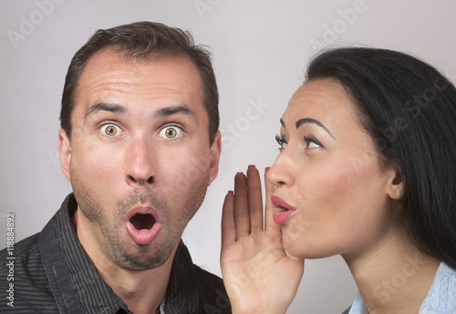 Woman sharing secret with surprised man