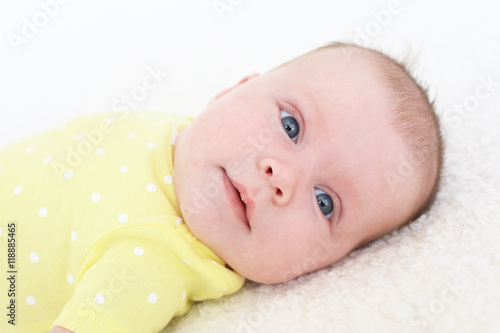 Portrait of lovely 2 months baby girl in yellow bodysuit