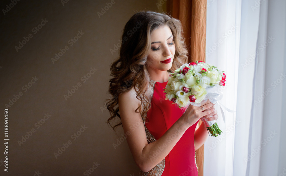 Beautiful bride in red dress holds white wedding bouquet Beautiful bride in red dress holds white wedding bouquet