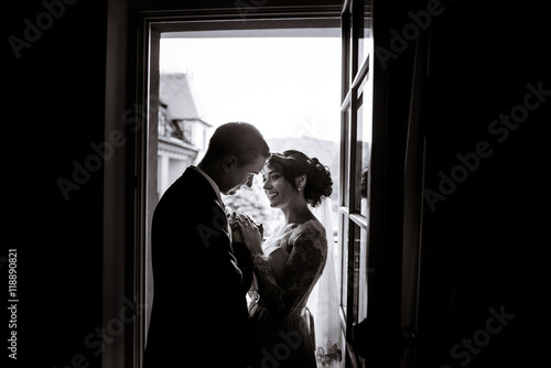 Silhouettes of happy newlyweds standing in door entrance