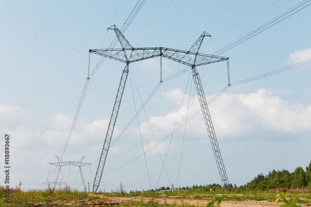 High-voltage transmission lines against the sky with clouds