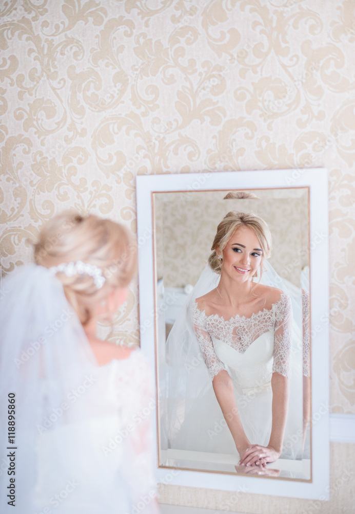 Stunning blonde bride looks in white mirror Stunning blonde bride looks in white mirror