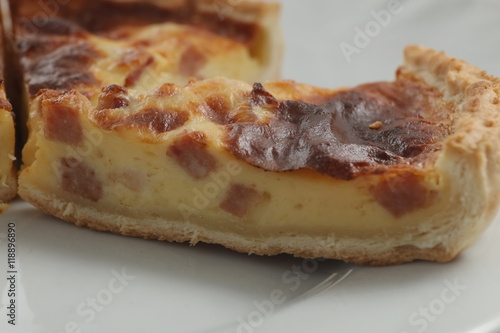 Fresh baked slice of quiche lorraine on a plate