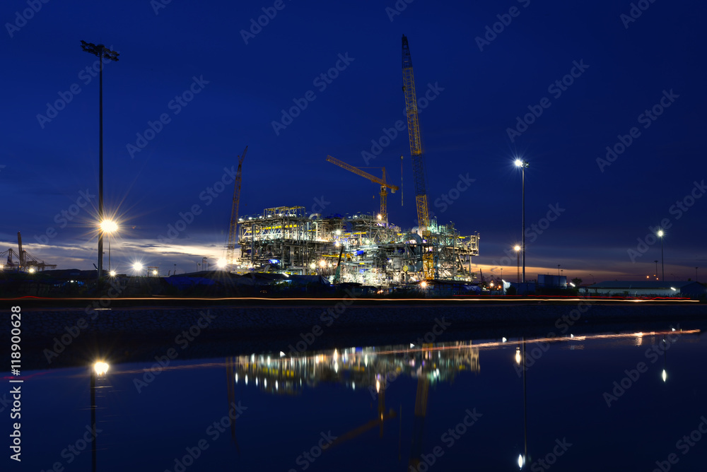 oil rig plant in construction at twilight .