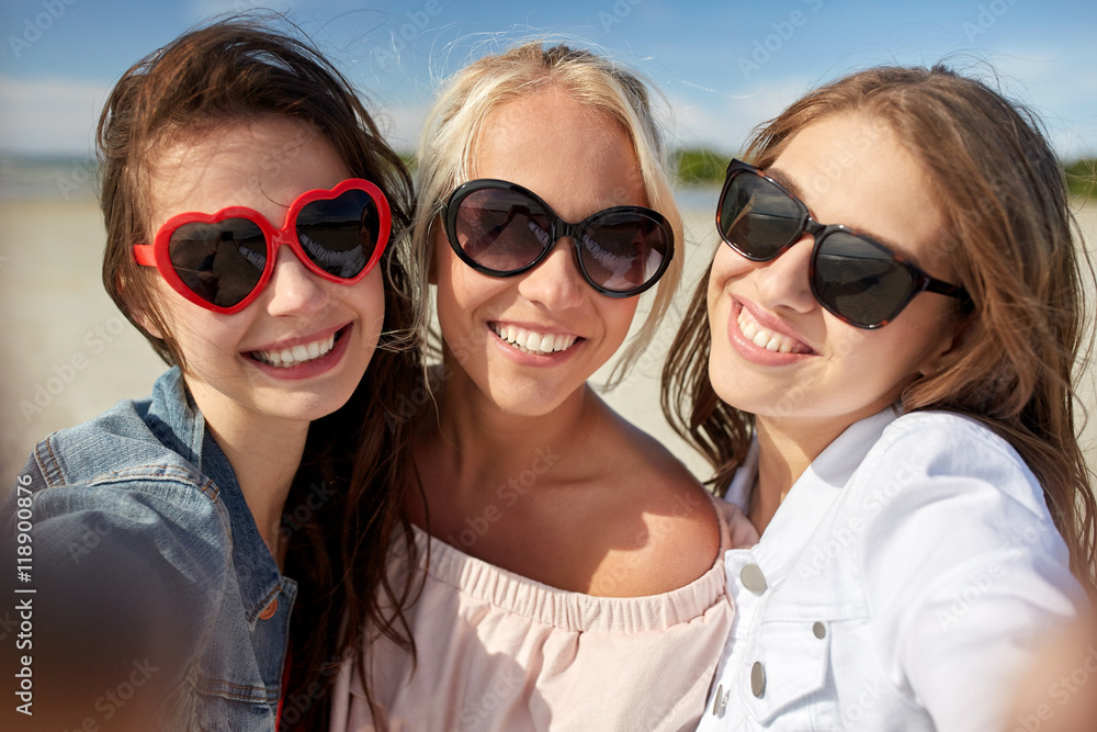 group of smiling women taking selfie on beach group of smiling women taking selfie on beach