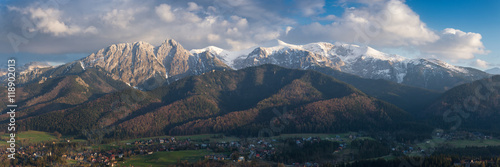 Panorama of snow-capped High Tatras on the Polish side, with a beautiful cloudy sky and a view of the city of Zakopane with many interesting details