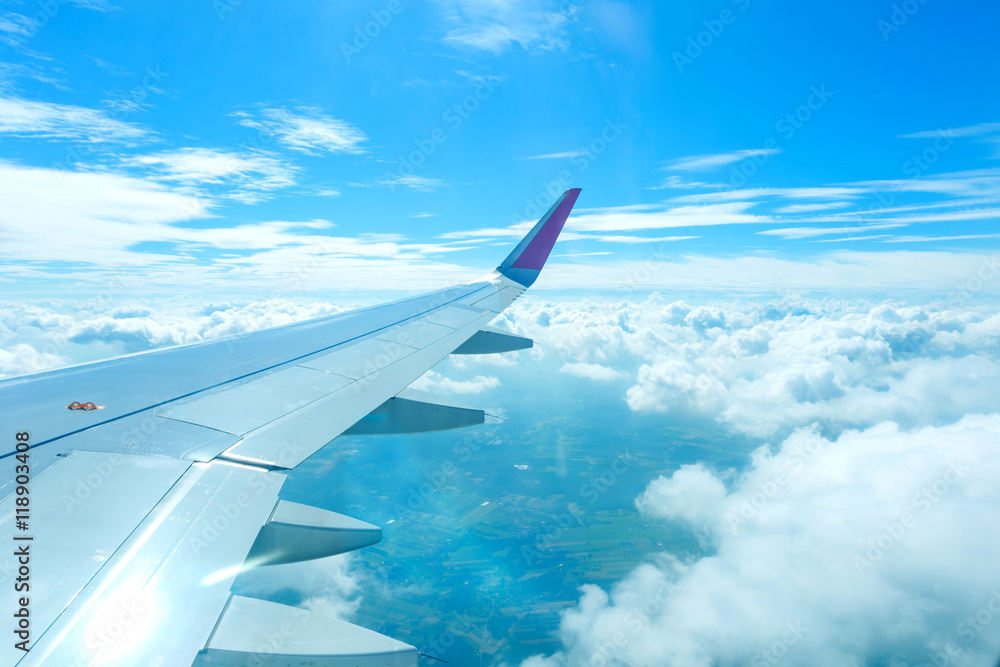 Obraz premium Airplane flying above clouds and sunrise