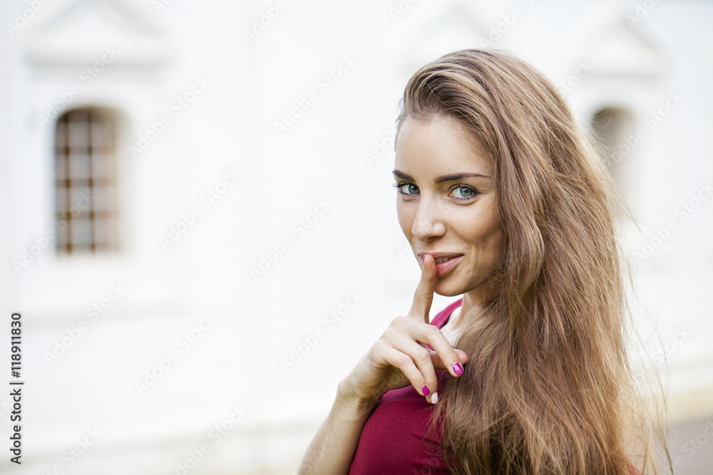 Young beautiful brunette woman has put forefinger to lips as sig Young beautiful brunette woman has put forefinger to lips as sig