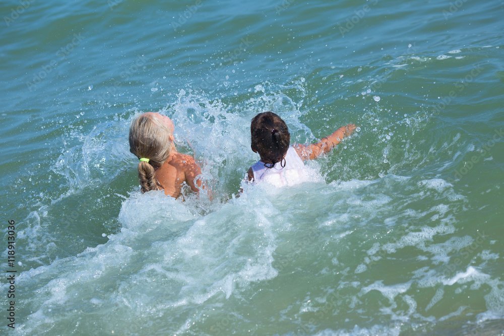 little girls bathing in the sea . summer, happiness, joy , sea