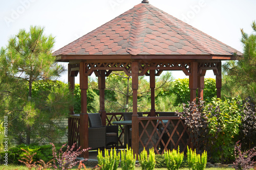 Outdoor wooden gazebo over summer landscape background