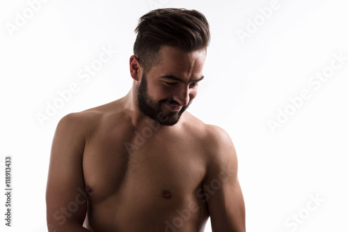 Portrait of happy naked handsome hipster man smiling and posing for fashion or vogue magazine isolated on white background in studio.