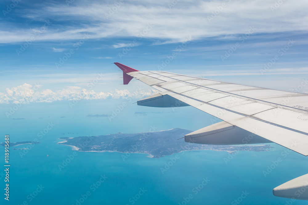 Fototapeta premium Skrzydło samolotu z widoku okna z Koh Samui w tle w Surat Thani, Tajlandia.