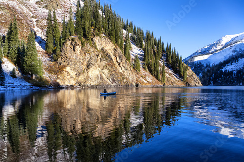 Autumn fishing after snowfall on the lake Kolsai, Kazakhstan photo