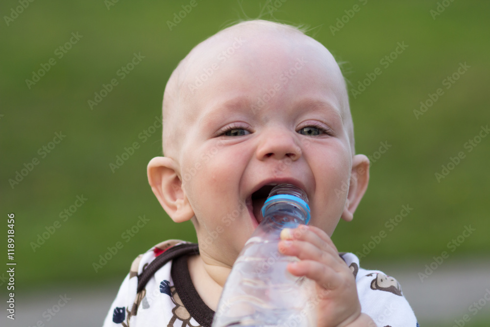 Cute baby boy playing and laughing in the park. Summer is around a lot of greenery interesting things for crumbs. Kid 1 year Cute baby boy playing and laughing in the park. Summer is around a lot of greenery interesting things for crumbs. Kid 1 year
