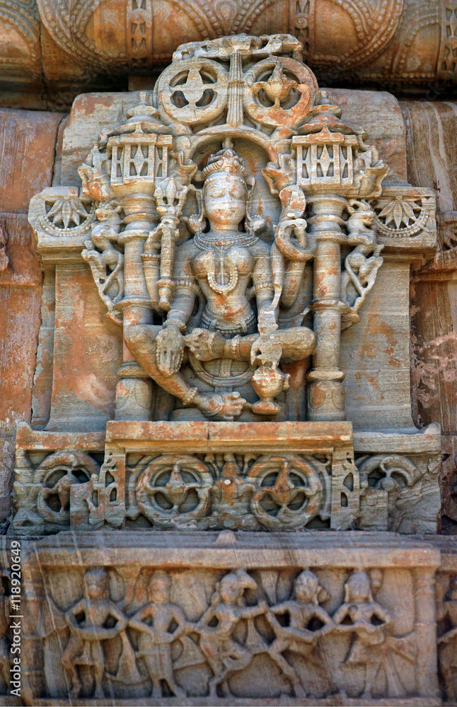 The carved sandstone ancient indian goddess on the outer wall of Hindu Temple, 11 century, in Ranakpur, India