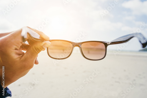 Sonnenbrille/Sonnenbrille in der Hand gegen die Sonne