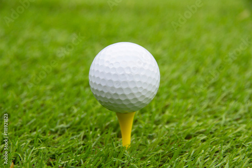 Golf ball on tee swing shot in grass green